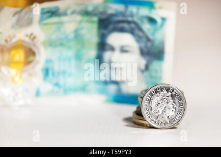 Fünf Pence Münze mit dem Bild von Elizabeth II. über ein unscharfes fünf Pfund von Großbritannien. Stockfoto