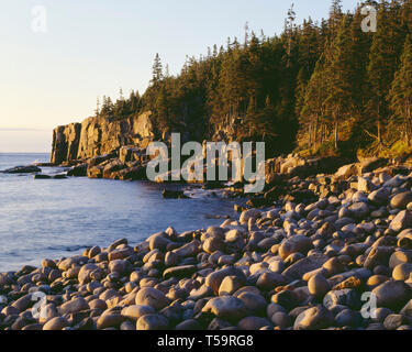 USA, Maine, Acadia National Park, Sunrise Welle abgerundete Felsen und Otter Cliffs zu beleuchten. Stockfoto