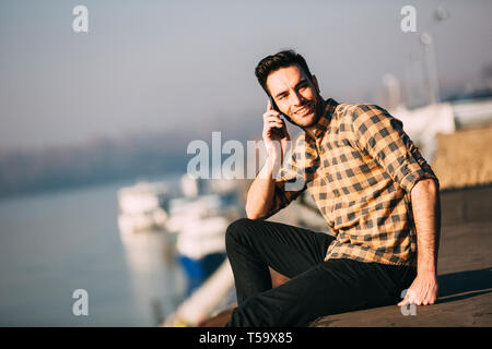Portrait von gutaussehenden jungen Mann mit Smart Phone. Stockfoto