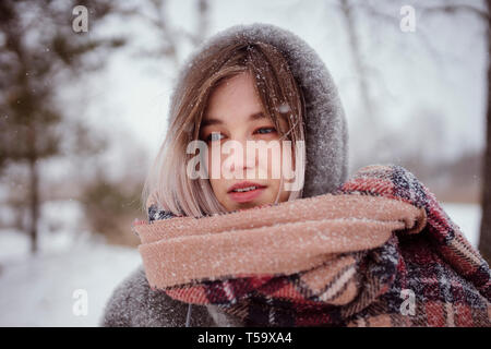 Porträt einer Frau, die in einem Schal und Haube im Winter Stockfoto