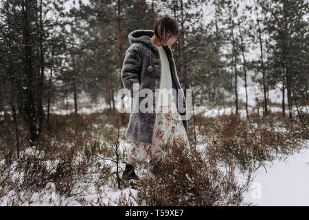 Eine Frau Spaziergänge in den Wäldern im Winter Stockfoto