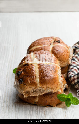 Ostern kreuzbrötchen am weißen Tisch Stockfoto