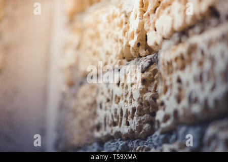 Alte Mauer aus Kalkstein mit grauen Nähten, Makro perspektivische Ansicht Stockfoto