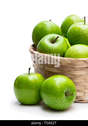 Grüne Äpfel in Weidenkorb isoliert auf weißem Reif Stockfoto