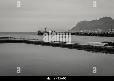 Der Rand der Gezeiten Pool auf der Kalk Bay Messing Glocke Restaurant auf der Kap Halbinsel, Western Cape, Südafrika und Blick auf den Hafen Stockfoto