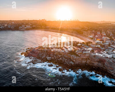 Bondi Beach Drone Schuß bei Sonnenuntergang mit Sydney CBD im Hintergrund bei Sonnenuntergang Stockfoto