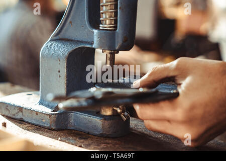 Mann arbeitet in der Schreinerei. Er behebt Holzgriff in einen Schraubstock spannen. Verschiedene Werkzeuge sind auf der Workbench. Männer an die Arbeit. Hand arbeiten. Stockfoto