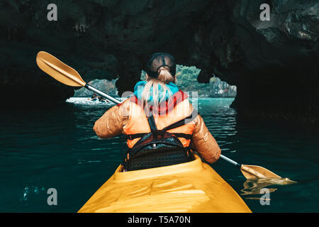 Frau erkunden und Paddeln im Kajak innen Karsthöhle in Ha Long Bucht. VietnamMountains und Meer Höhle, Reisen nach Asien, Glück Emotion, Sommer holida Stockfoto