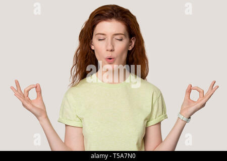 Junge rothaarige Mädchen meditieren, Yoga im Studio Stockfoto