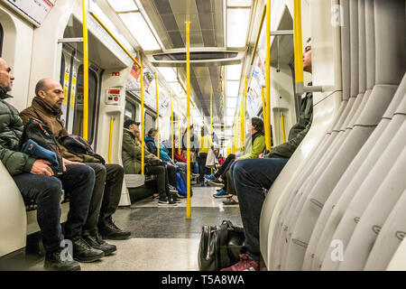 Passagiere in einem Schlitten auf einer Londoner U-Bahn sitzen. Stockfoto