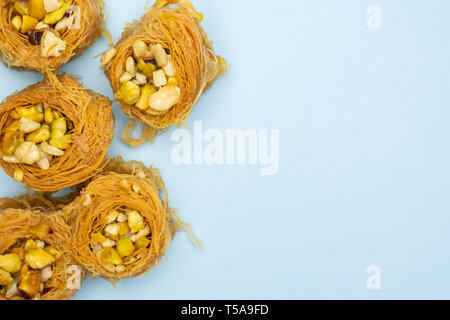 Gruppe von fünf ganze süsse Libanesen baklava Stück Vogelnest Vielzahl copyspace flatlay auf Sky blau Hintergrund isoliert Stockfoto