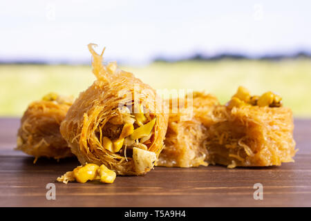 Gruppe von fünf ganze süsse Libanesen baklava Stück Vogelnest Sorte mit grünem Weizenfeld Stockfoto