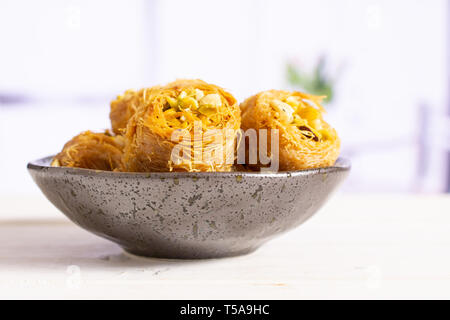 Menge ganz süße Libanesen baklava Stück Vogelnest Vielfalt auf Grau keramische Platte in einem weißen Küche Stockfoto