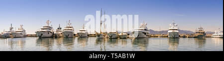 CANNES, Frankreich - April 2019: Panoramablick auf Super Yachten im Hafen Pierre Canto Marina in Cannes günstig, mit Gebäuden im Hintergrund. Stockfoto