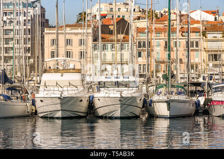 CANNES, Frankreich - April 2019: Luxus Yachten im Hafen von Cannes vor Anker, mit Gebäuden im Hintergrund. Stockfoto