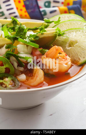 Würzige mexikanische Garnelen Suppe Caldo de Camaron mit Avocado gewürfelte Zwiebeln, Koriander und Limettensaft Keil garnieren Stockfoto