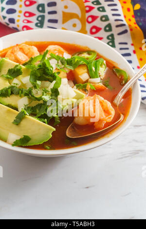 Würzige mexikanische Garnelen Suppe Caldo de Camaron mit Avocado gewürfelte Zwiebeln, Koriander und Limettensaft Keil garnieren Stockfoto