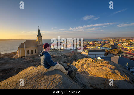 Touristische auf einem Hügel genießt die Aussicht von Lüderitz in Namibia bei Sonnenuntergang Stockfoto