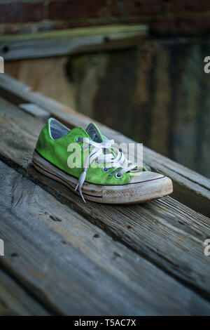 Alten, stinkenden getragen classic Sneaker auf Stadt Straße verloren Stockfoto