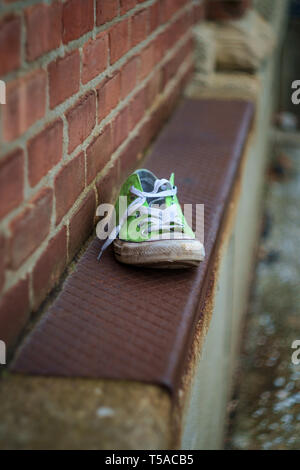 Alten, stinkenden getragen classic Sneaker auf Stadt Straße verloren Stockfoto