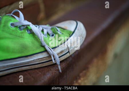 Alten, stinkenden getragen classic Sneaker auf Stadt Straße verloren Stockfoto