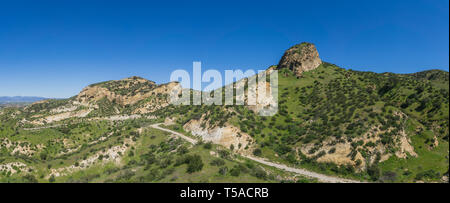 Einsame wandern Pfad schlängelt sich unter dem Hügel von einem Gras bedeckte Hügel in Südkalifornien. Stockfoto