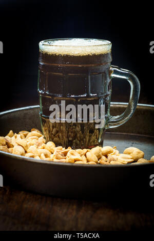 Schaumiges Bier Pub Erdnüsse geschält Salz auf hölzernen Bar Tabelle Stockfoto