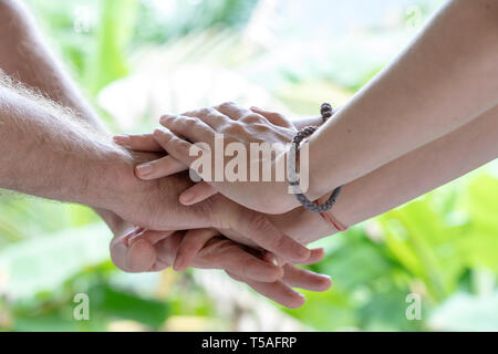 Arm eins zusammen gestapelt in Einheit und Teamarbeit. Viele Hände treffen sich in der Mitte eines Kreises. Close Up Outdoor geschossen. Viele Hände connec Stockfoto