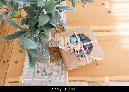 Cupcake Verpackungen auf Holztisch, Lieferung, Vanille Cupcakes mit blauen und weißen Creme. Ansicht von oben, kopieren Platz für Text Stockfoto