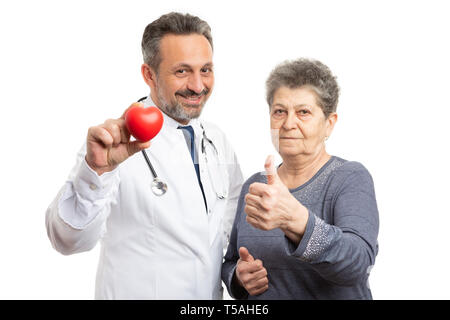 Freundliche männliche Kardiologen mit roten Herzen und Patient holding Daumen hoch, wie wie Geste auf weißem Hintergrund Stockfoto