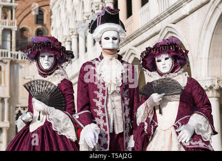 Drei maskierte Menschen tragen rote und weiße Karneval Kostüme, Carnevale di Venezia, Venedig, Italien Stockfoto