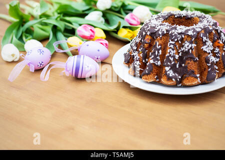 Tulpen, Eier und Gebäck auf Holzplatten Stockfoto