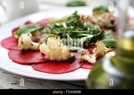 Gemüse rote Beete Carpaccio mit Blumenkohl und grünen Salat. Stockfoto