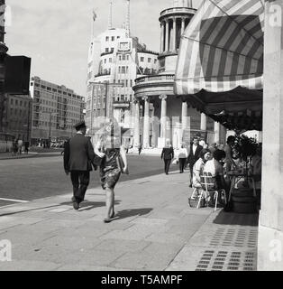 1960, historische, Marylebone, London, Leute, entspannend, draußen sitzen ein Cafe am nördlichen Ende der Regent Street, mit der BBC Broadcasting House in Portland Place und alle Seelen Kirche im Langham Place auch im Bild. Stockfoto