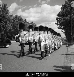 1960, historische, 1.BATAILLON Grenadier Guards Corps der Trommeln in voller Uniform und bärenfellmütze Helme marschieren entlang der Mall, der Straße zwischen Buckingham Palace und Trafalgar Square, London, England, Stockfoto