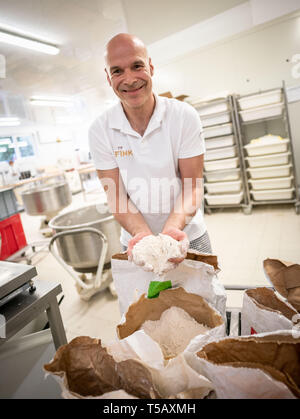 17. April 2019, Hessen, Steinau an der Straße: In seinem Bäcker, bäckermeister Jürgen Fink steht von einem Sack von organischen Dinkelmehl, die er in seinem Brot neben andere regionale Produkte verwendet. Unter dem Motto "Backen mit Liebe und Zeit', die Firma, die Familie seit vielen Generationen im Familienbesitz, arbeitet nach alten handwerklichen Traditionen ohne industrielle Backmischungen oder tiefgekühlte Teige. Foto: Frank Rumpenhorst/dpa Stockfoto