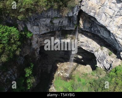 Peking, China. 22 Apr, 2019. Luftbild am 22. April 2019 zeigt ein Wasserfall in Didonghe Tiankeng, einem riesigen Karst doline an Huoshizi Dorf Ningqiang County in Hanzhong, Provinz Shaanxi im Nordwesten Chinas. Mit einer maximalen Tiefe von 340 Metern, die Didonghe Tiankeng ist die größte in Chanjiayan Tiankeng Gruppe in Ningqiang County. Credit: Zhang Bowen/Xinhua/Alamy leben Nachrichten Stockfoto