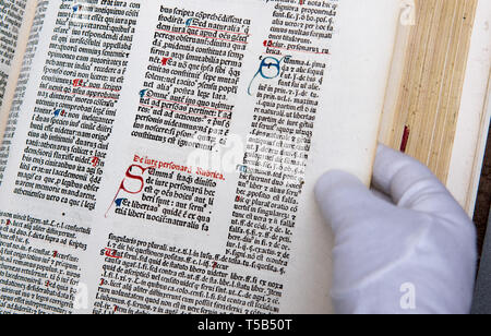 23. April 2019, Sachsen, Chemnitz: Ein Mitarbeiter der Chemnitzer Stadtbibliothek treibt durch die wiederhergestellten Consilia des Nicolaus Panormitanus de Tudeschis in der Stadtbibliothek Chemnitz. Die schwer beschädigte Buch hat nun restauriert und vom Zerfall für rund 1500 Euro gespeichert. Die Sammlung von juristischen Dokumenten und Rechtsgutachten wurde 543 Jahre vor in Movable Type in Ferrara, Rom und Venedig gedruckt. Die gedruckten Blätter dann die Alpen nach Leipzig. Gibt die Bögen wurden in Folianten und fortan gebunden bereichert die Bibliothek der TU Chemnitz Franziskanerkloster. Vermutlich gibt es nur vier Editionen l Stockfoto