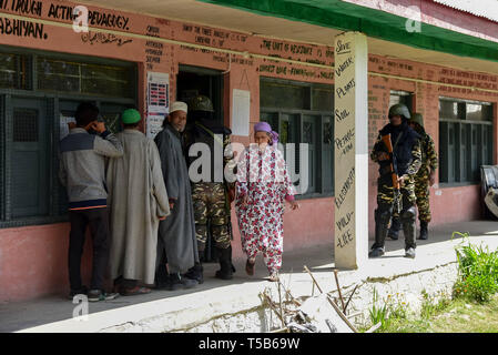 Anantnag, Jammu und Kaschmir, Indien. 23 Apr, 2019. Die regierungstruppen gesehen stehen auf der Hut wie Kaschmir Wähler in einer Warteschlange stehen, ihre Stimmen vor einem Wahllokal in Anantnag, in Kaschmir zu werfen. In der dritten Phase der Parlamentswahlen in Indien Wahlen, Inder, die auf Umfragen unter komplett heruntergefahren und Internet gag ging. Kredit Idrees: Abbas/SOPA Images/ZUMA Draht/Alamy leben Nachrichten Stockfoto