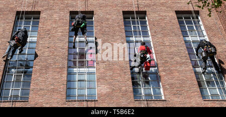 Berlin, Deutschland. 23 Apr, 2019. Fensterputzer hängen an Seilen in eine Hausfassade in der Leibnitzstraße in Charlottenburg gesichert und die Scheiben reinigen. Credit: Paul Zinken/dpa/Alamy leben Nachrichten Stockfoto