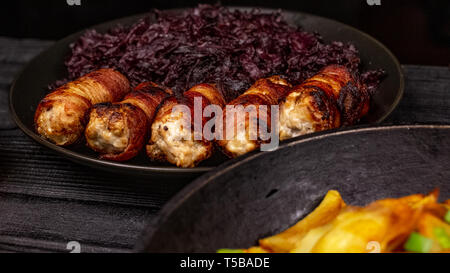 Gebratene hausgemachte gegrillte Würstchen oder chevapchichi mit Schmorkohl auf Holz rustikale Hintergrund. Stockfoto