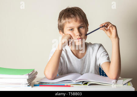 Traurig müde Junge Hausaufgaben machen. Bildung, Schule, Lernschwierigkeiten Konzept. Stockfoto