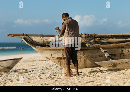 Arme afrikanische Fischer Instandsetzung seiner alten hölzernen Boot auf dem Ozean Stockfoto