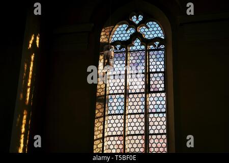 Schöne alte Fenster in der deutschen katholischen Kirche. Licht und Schatten. Details Stockfoto