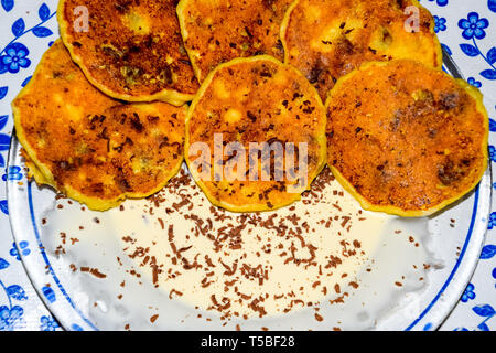 Käsekuchen mit saurer Sahne und Schokolade Chips auf einer Platte. Stockfoto