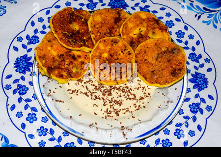 Käsekuchen mit saurer Sahne und Schokolade Chips auf einer Platte. Stockfoto