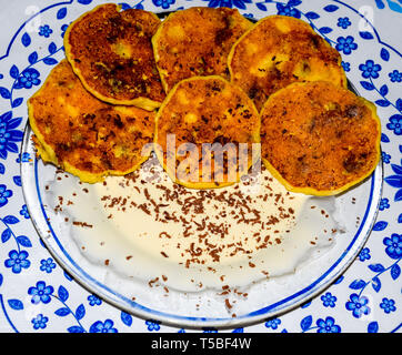 Käsekuchen mit saurer Sahne und Schokolade Chips auf einer Platte. Stockfoto