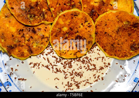 Käsekuchen mit saurer Sahne und Schokolade Chips auf einer Platte. Stockfoto