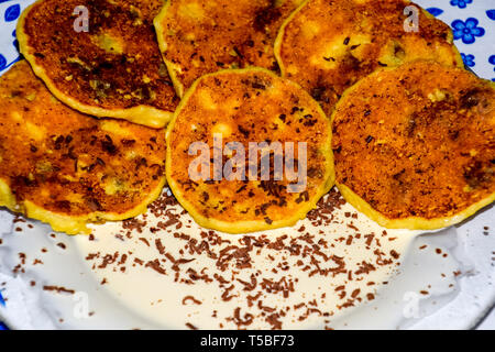 Käsekuchen mit saurer Sahne und Schokolade Chips auf einer Platte. Stockfoto
