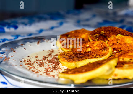 Käsekuchen mit saurer Sahne und Schokolade Chips auf einer Platte. Stockfoto
